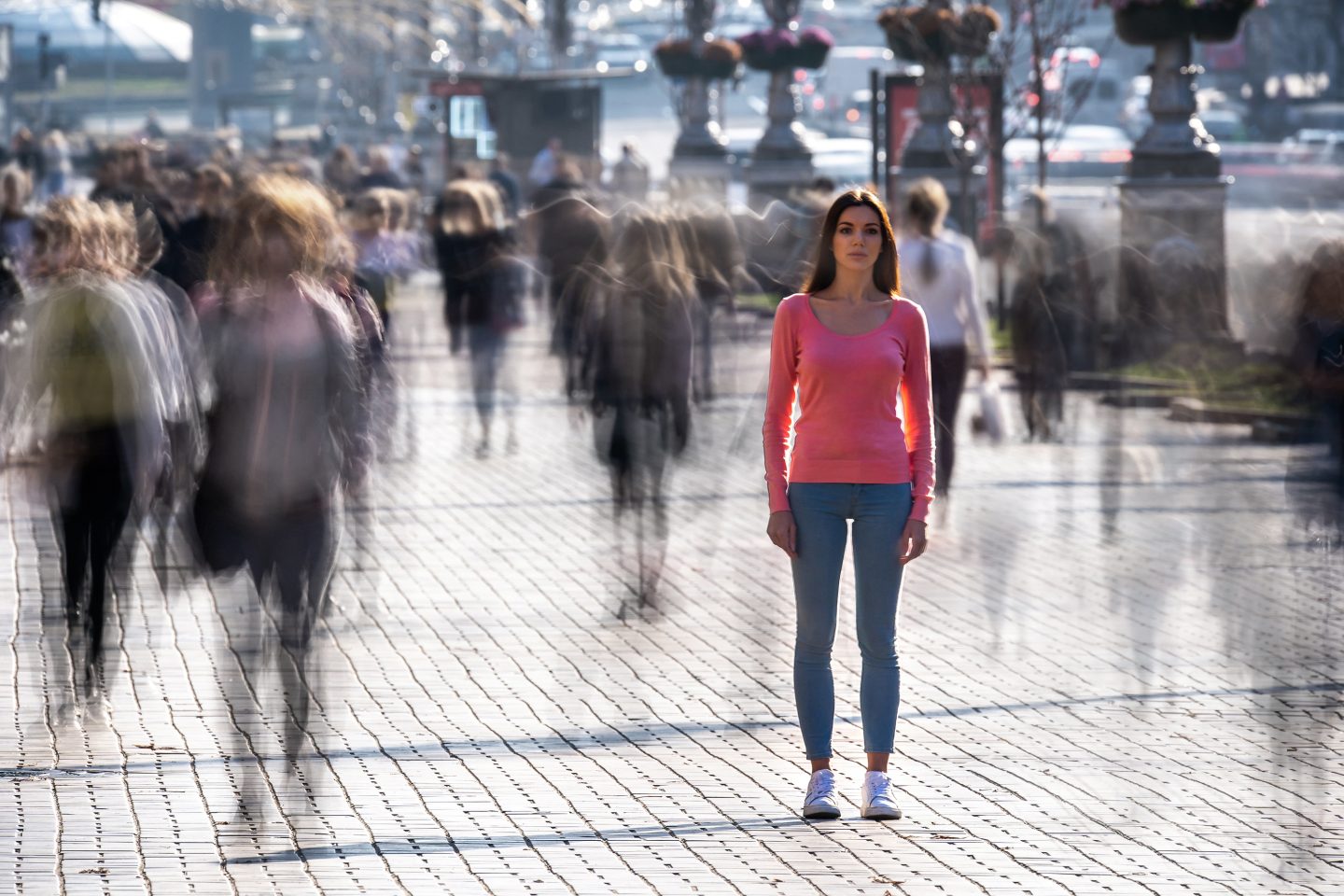 Woman stands in the middle of crowded street.